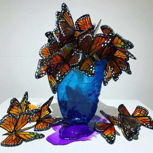 Translucent vase filled with monarch butterflies